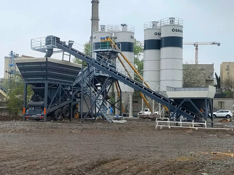 Newly installed GRAU G100M mobile concrete plant with four cement silos, seen across a bare earth site