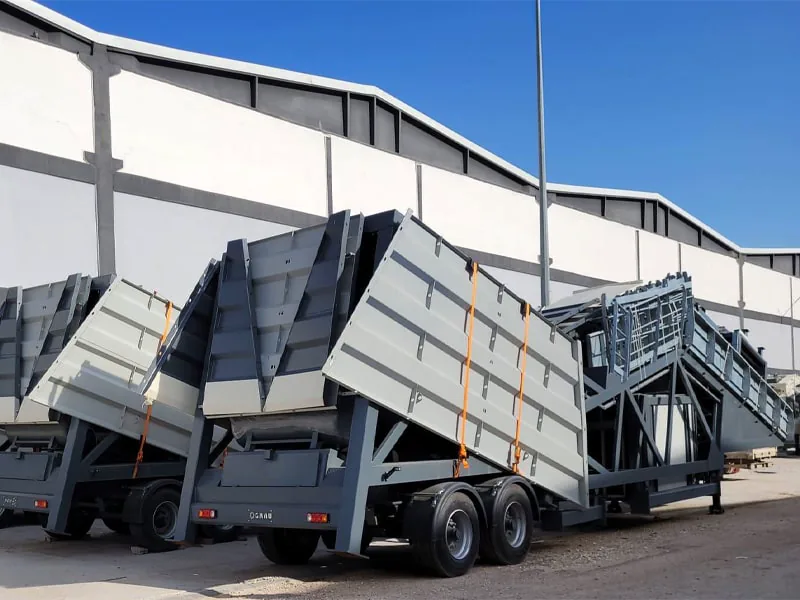 GRAU G100M folded into transport position on its wheelbase beside another folded unit, outside a factory hall