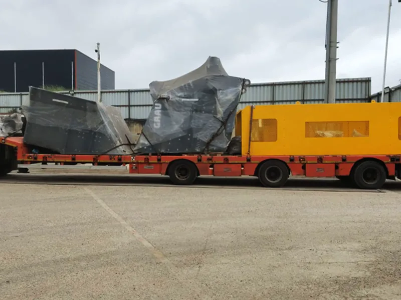 GRAU primary impact crusher wrapped in plastic sheeting on a low-loader trailer for despatch