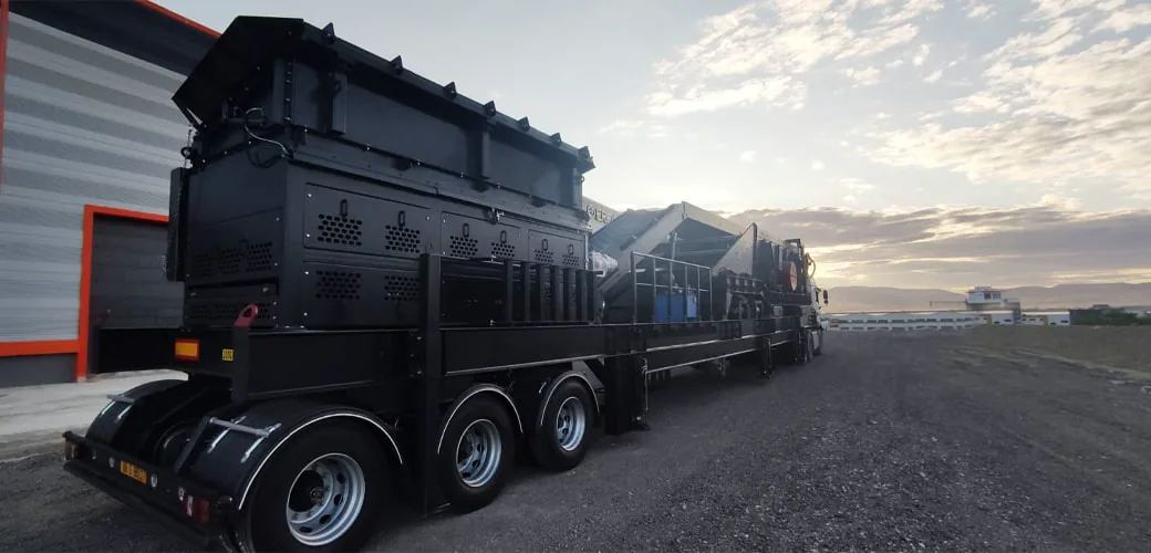 Installation de lavage portable GRAU noire sur son châssis au crépuscule, vue de l’arrière à côté d’un bâtiment