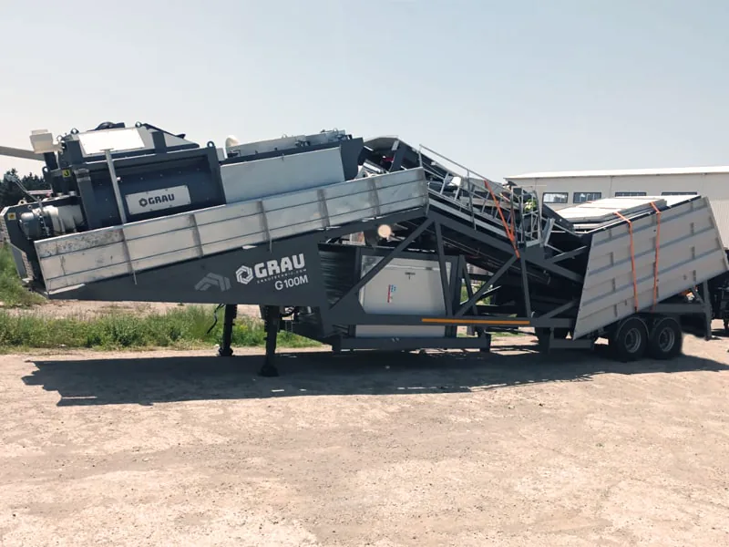 GRAU G100M mobile concrete plant folded into transport position on its trailer chassis, resting on its front legs